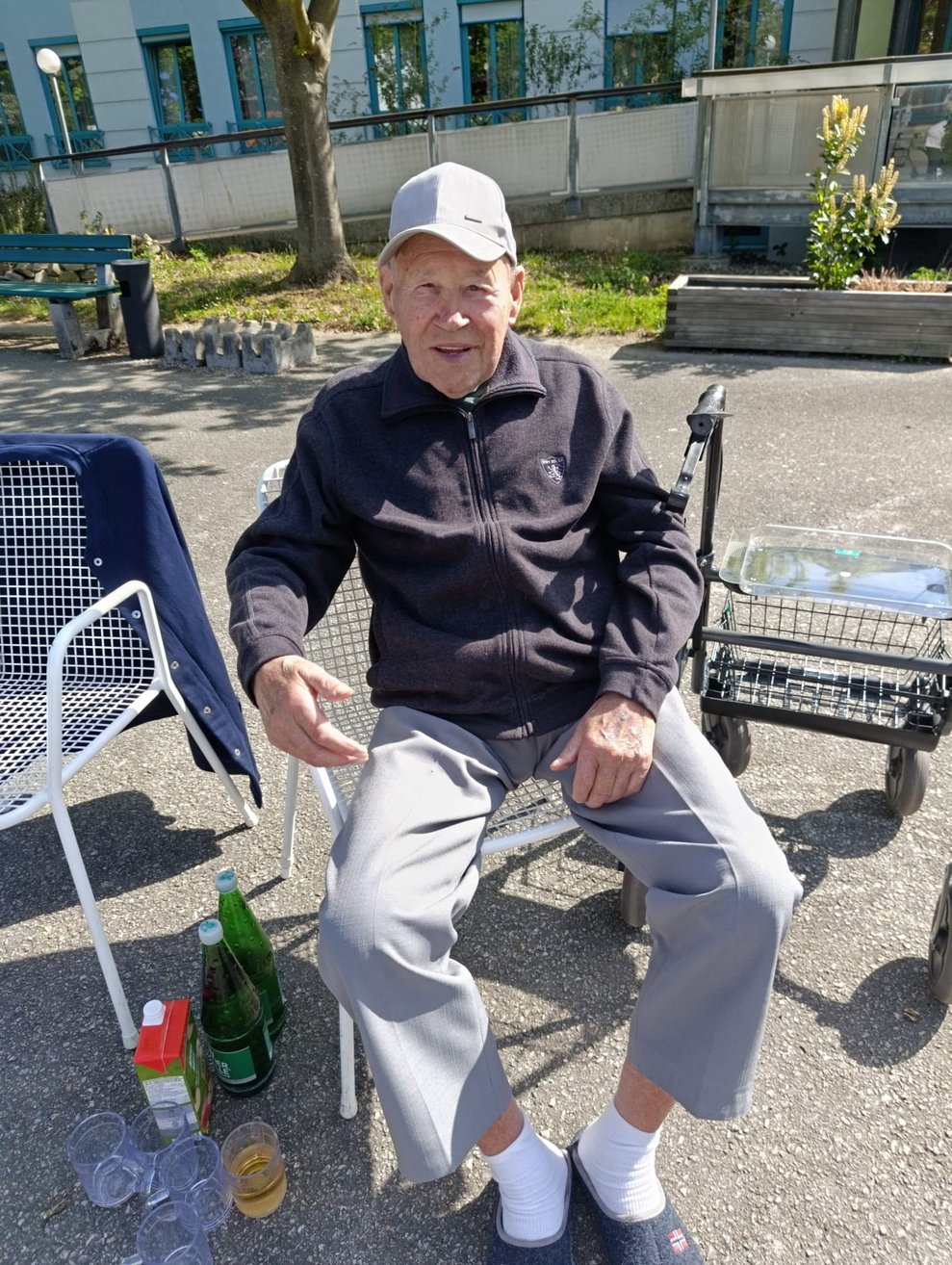Lächelnder Bewohner sitzt im Garten.
