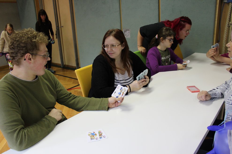 Mehrere Personen spielen ein Kartenspiel