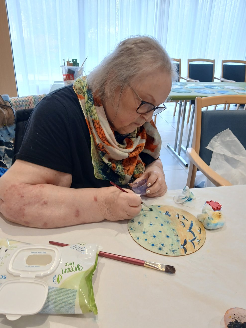 Frau bemalt Holzscheibe