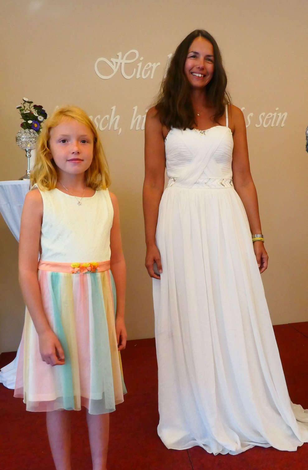 Eine Braut mit einem Mädchen im Regenbogenkleid.