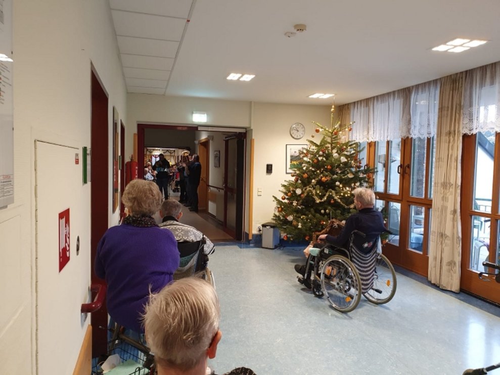 BewohnerInnen sitzen im Gang.