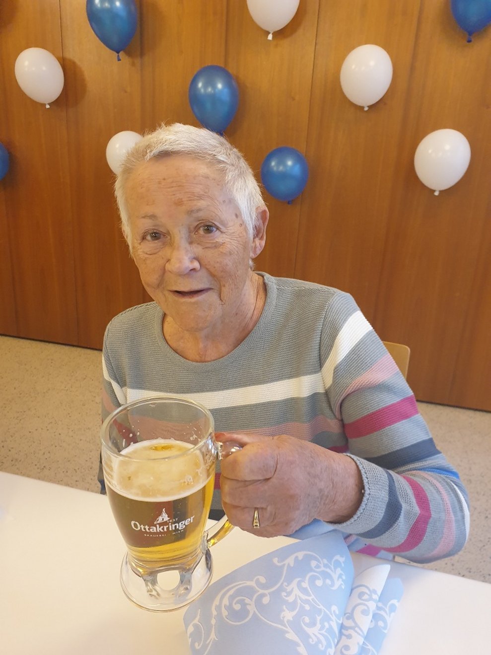 Eine Bewohnerin hält einen Bierkrug.