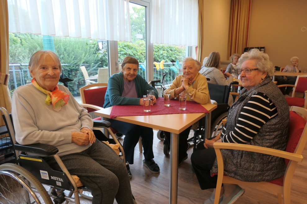 Vier Damen bei Tisch.