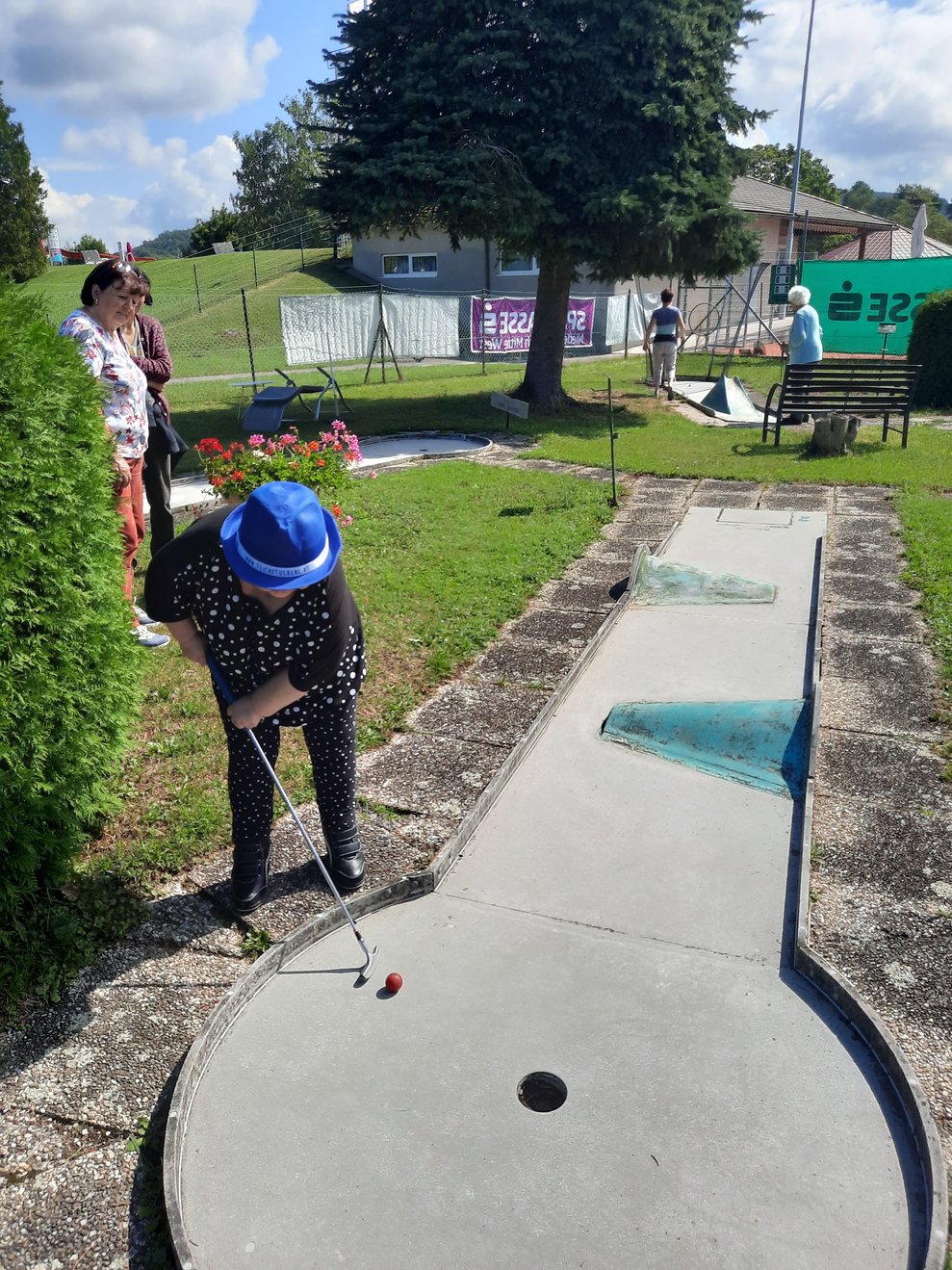 Eine Dame spielt Minigolf.
