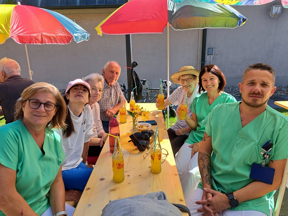 Männer und Frauen sitzen um den Tisch. 