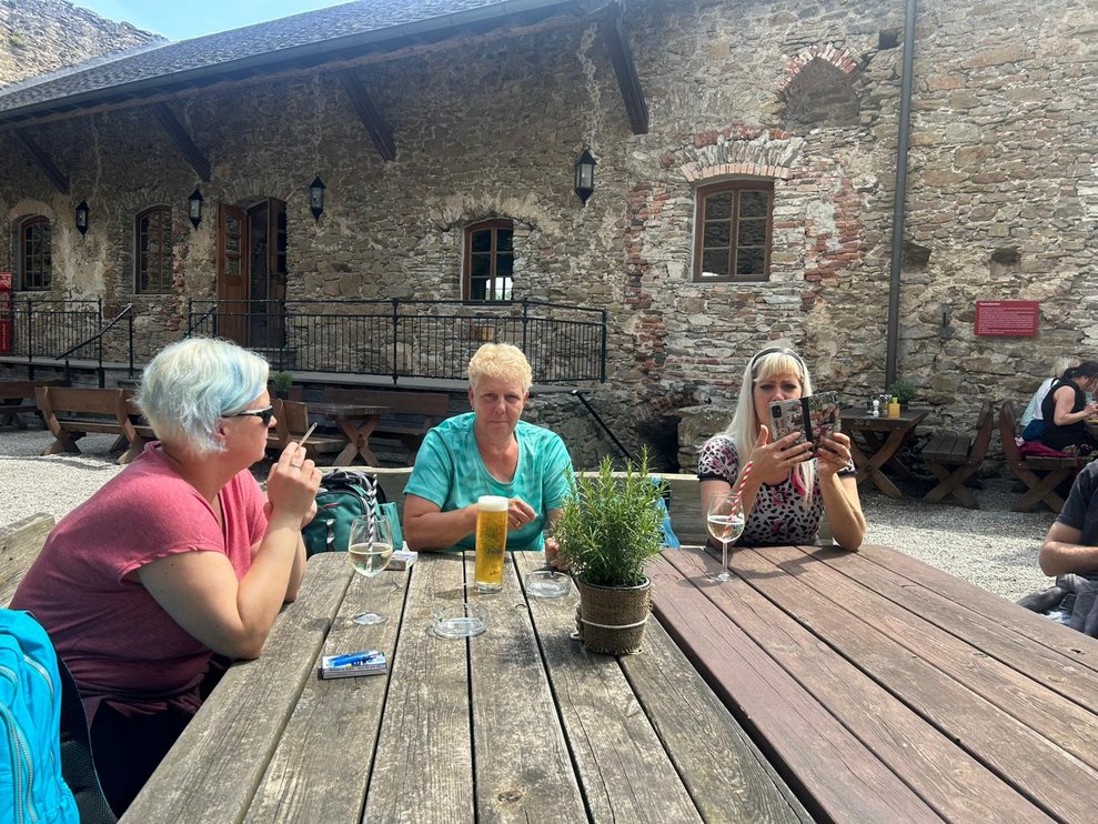 Tisch im Burginnenhof wo 3 Frauen sitzen und trinken
