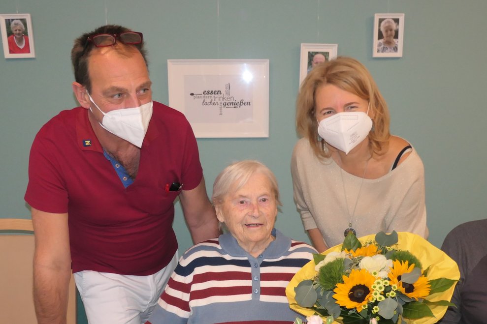 Ein Mann und Zwei Frauen mit Blumen