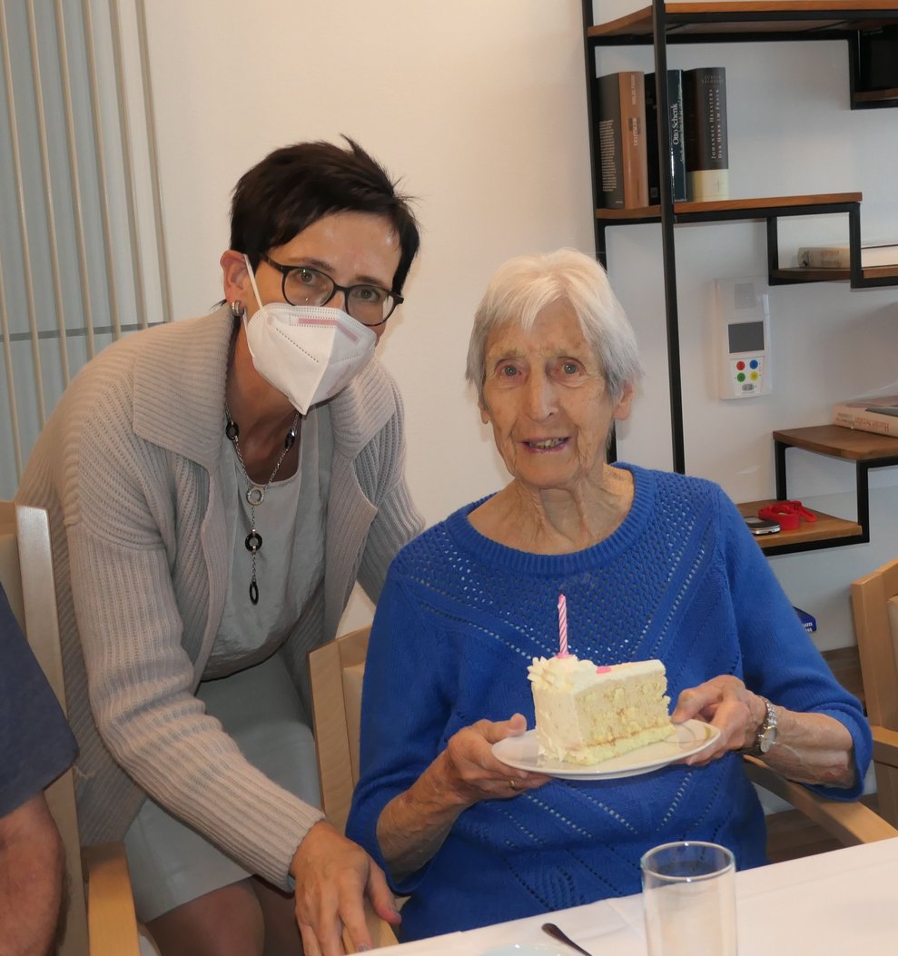 Zwei Frauen, eine der Damen hält ein Stück Torte.