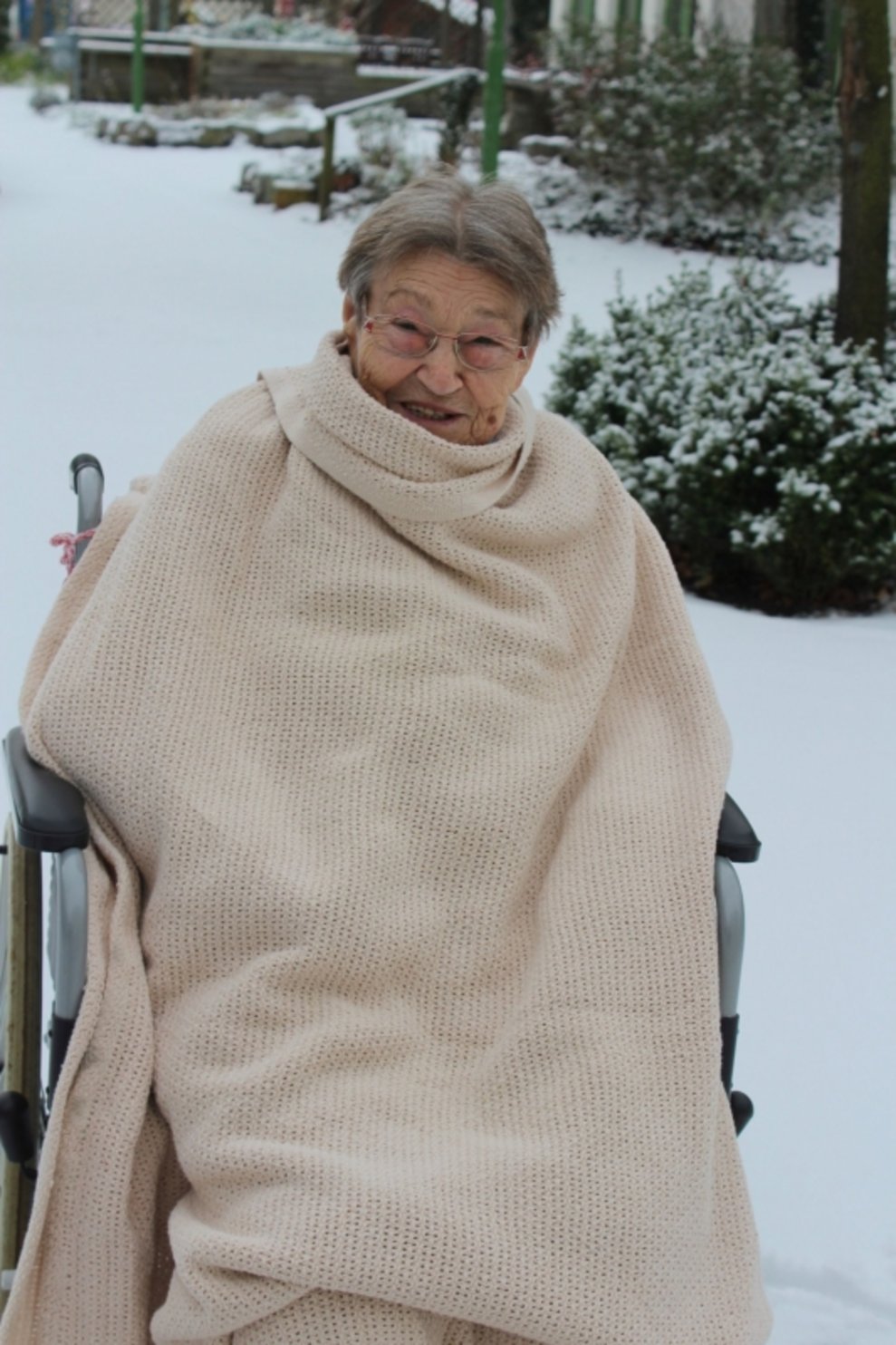 Eine Bewohnerin ist draußen beim Schnee.