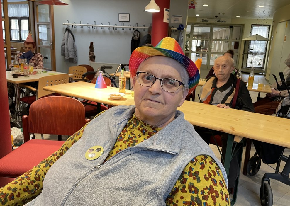 Eine Dame mit buntem Hut.