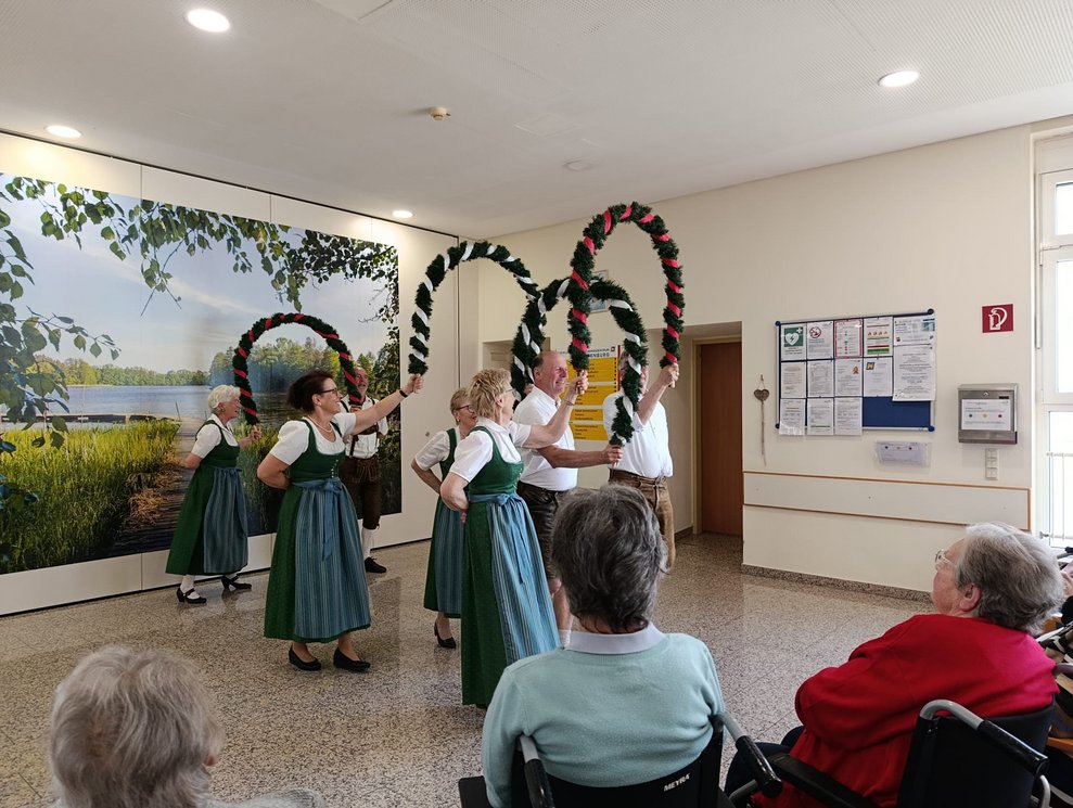 MitgliederInnen der Volkstanzgruppe Rosenburg/Mold tanzen mit Bögen.