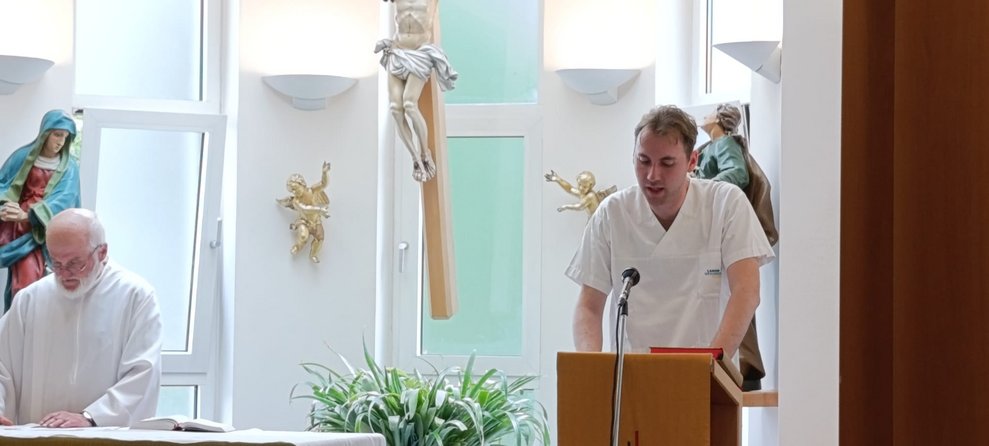 Zwei Männer in der Hauskapelle am Altar stehend.