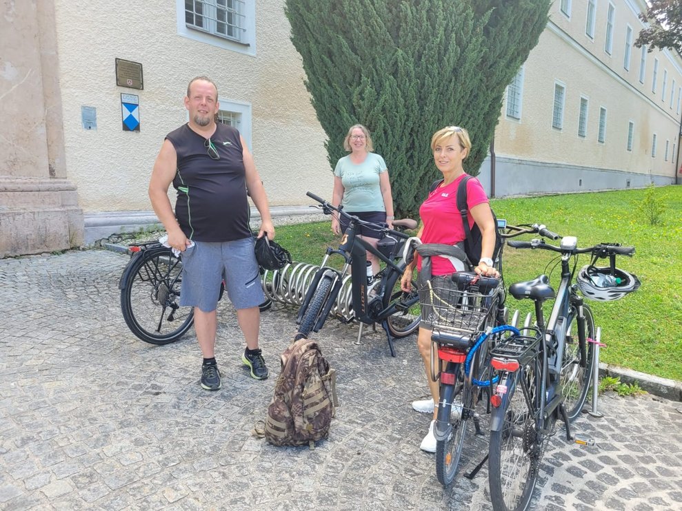 3 Personen posieren mit Fahrrad vorm Stift Lilienfeld.