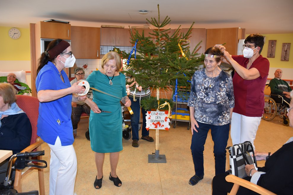 BewohnerInnen und BetreuerInnen schmücken Maibaum.