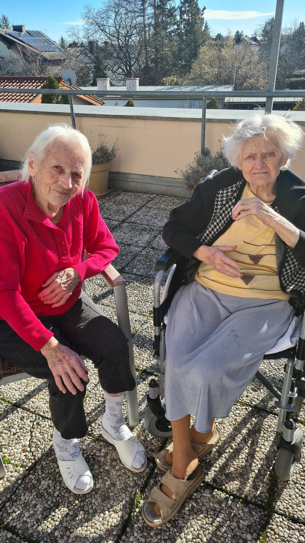 Zwei Damen die das schöne sonnige Wetter auf der Terrasse genießen.