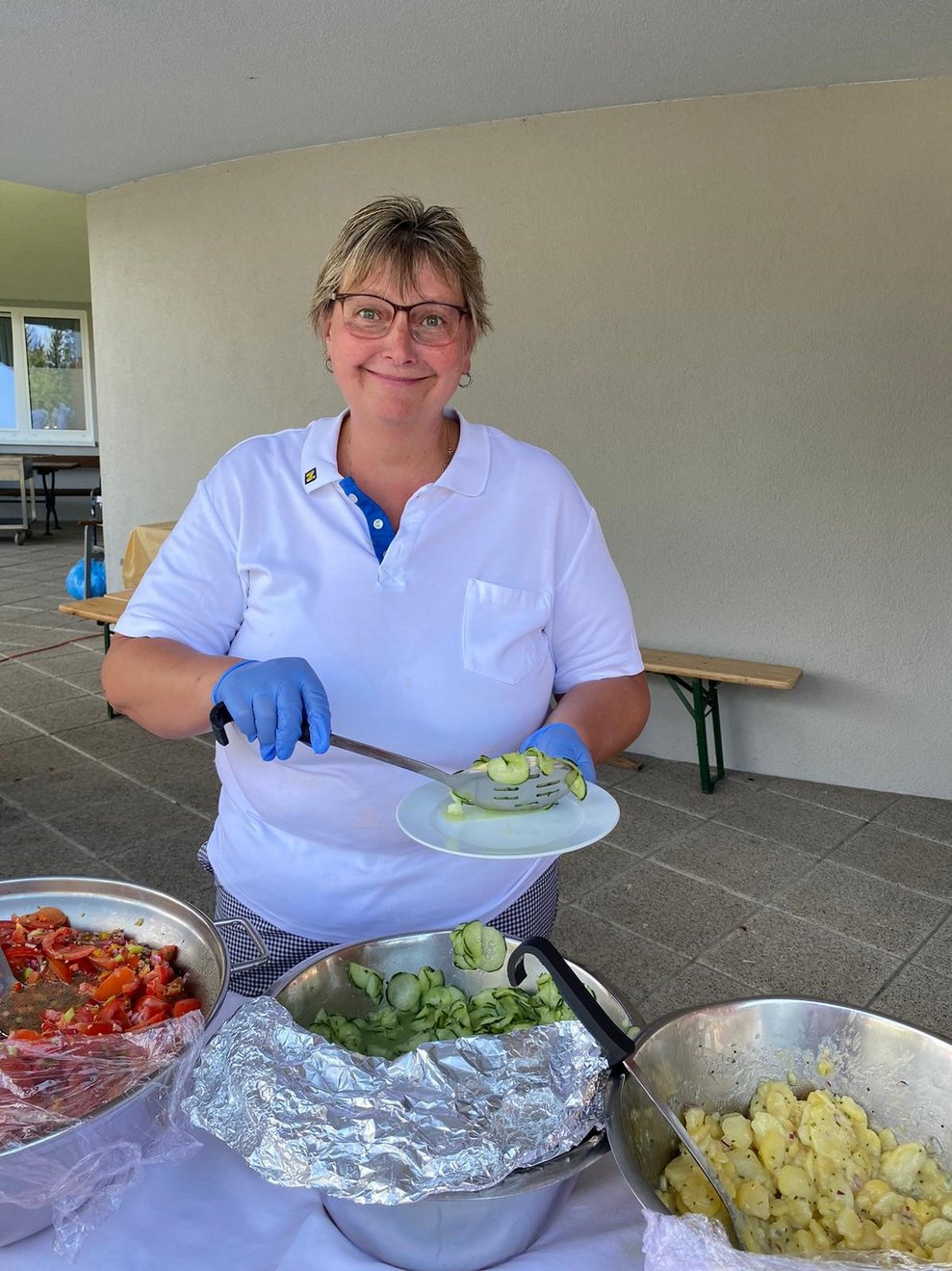 Sonja aus der Küche gibt den Salat aus