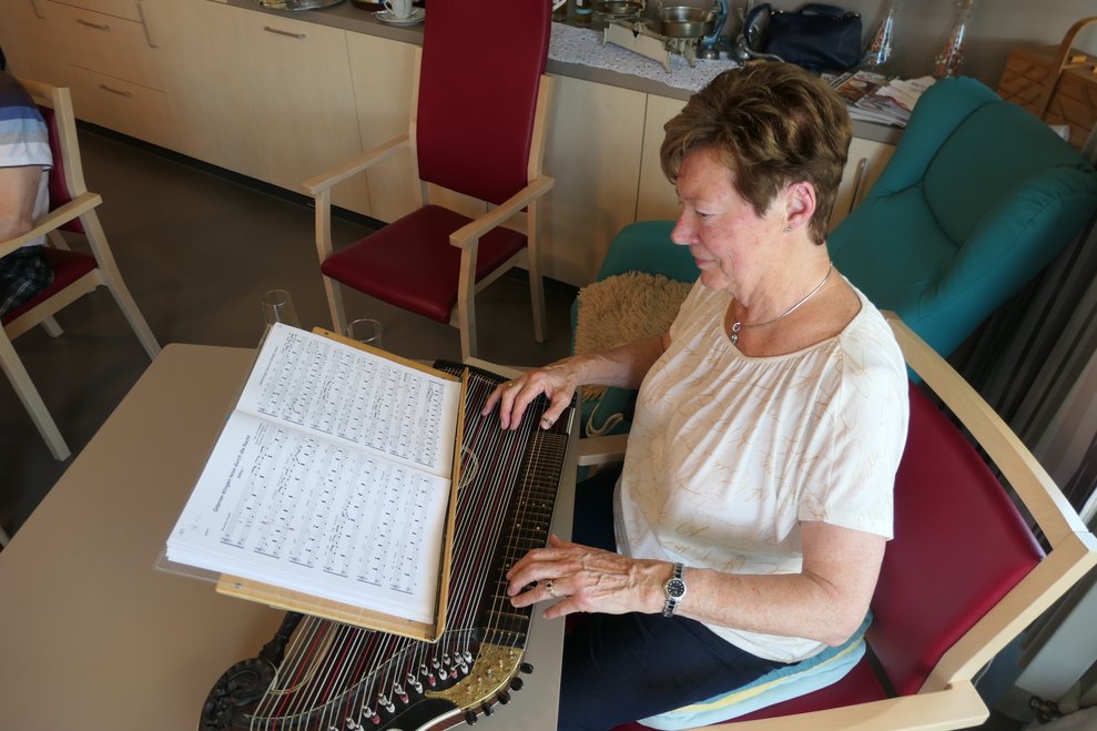 Eine Dame spielt auf der Zither