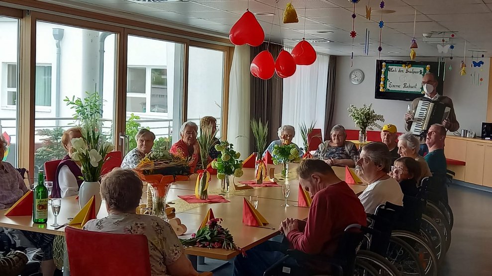 BewohnerInnen sitzen bei einem Tisch.