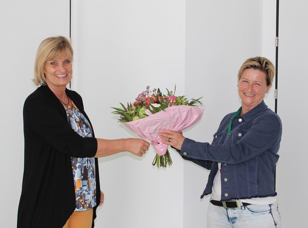 Direktorin Stanzel übergibt einen Blumenstrauß an Ulrike Gross.