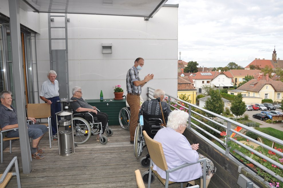 BewohnerInnen sitzen am Balkon.