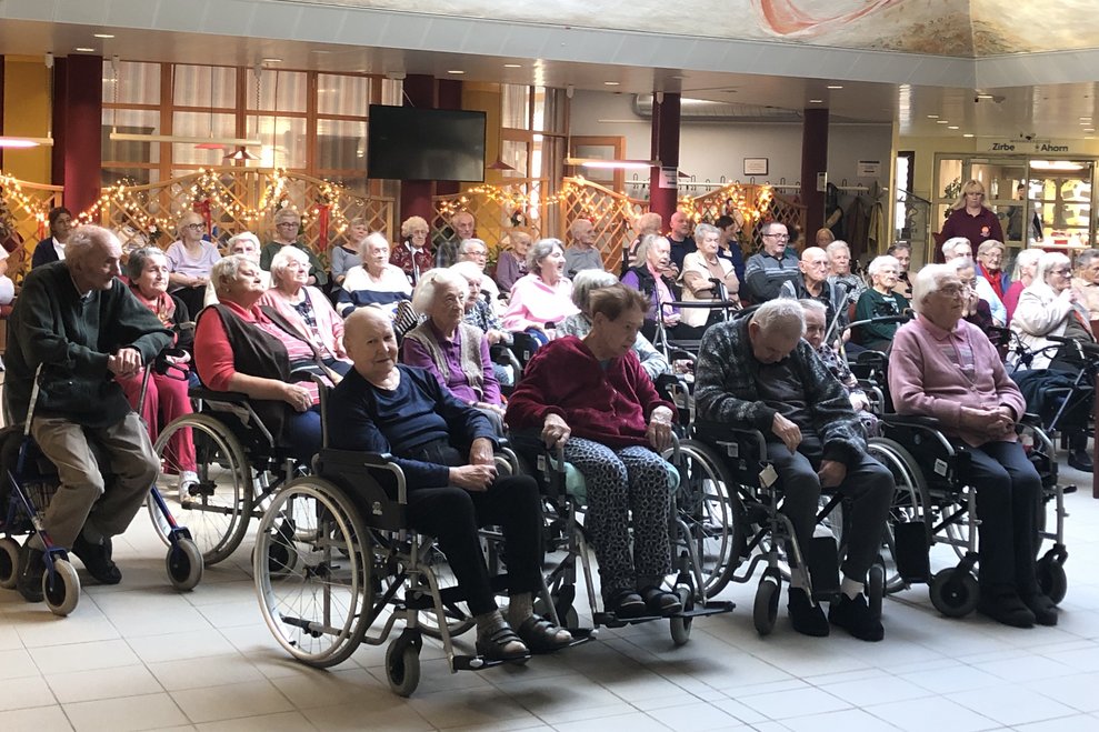 Bewohnerinnen und Bewohner lauschen dem Konzert. 
