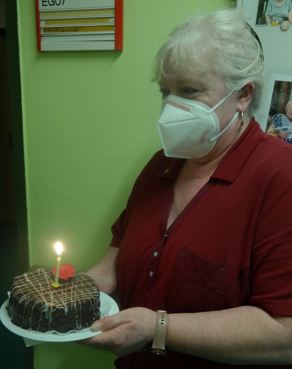 Eine Betreuerin hält eine Torte in der Hand.