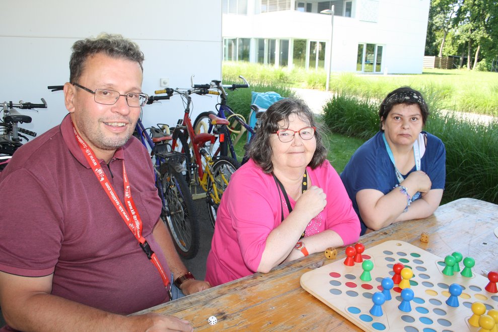 Personen sitzen bei einem Tisch und spielen