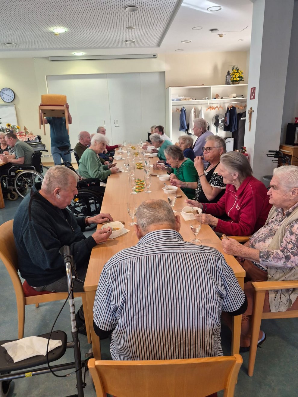 Personen beim Gemüsesuppe und Brot essen.