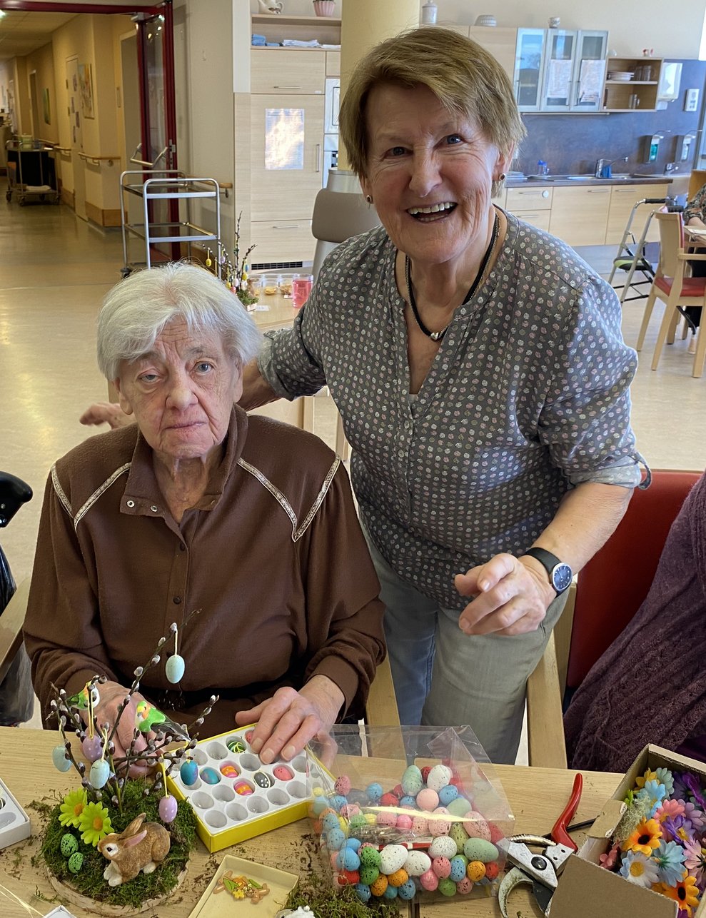 Ehrenamtliche Mitarbeiterin Eva bastelt mit Frau Kautz. 