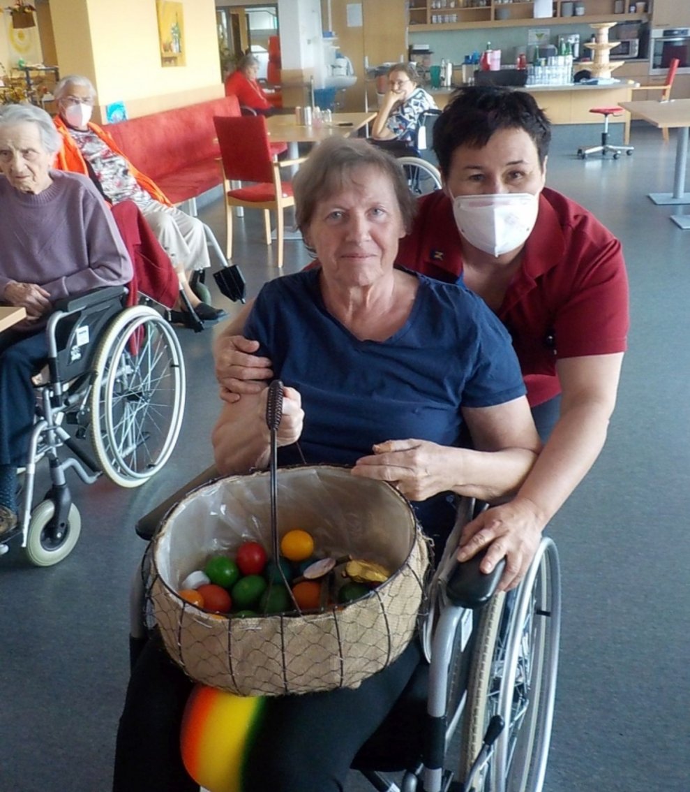 Eine Betreuerin und eine Bewohnerin verteilen Eier.