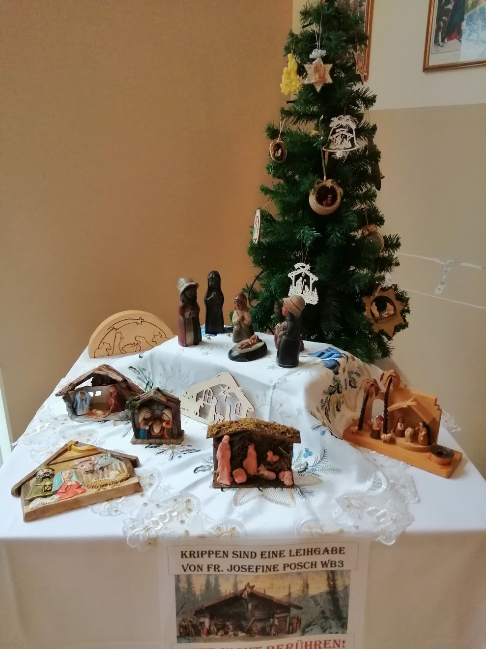 Krippen vor einem Weihnachtsbaum.
