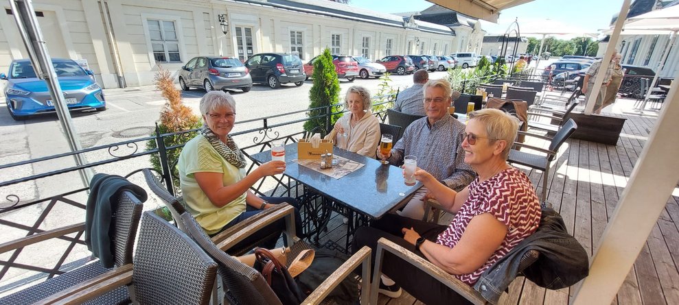 Damen und Herr stoßen mit Getränken an