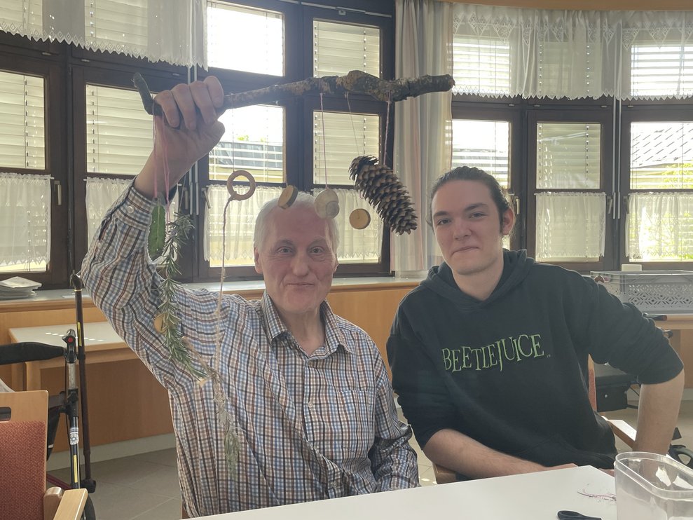 Ein Schüler und ein Bewohner beim Basteln.