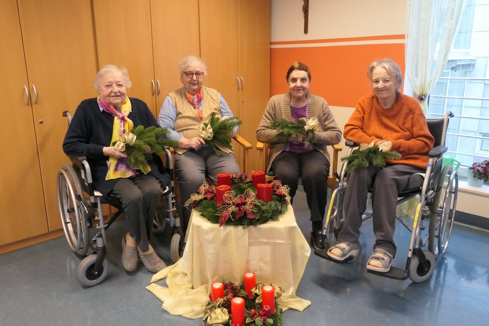 Vier Personen mit den Adventkränzen.