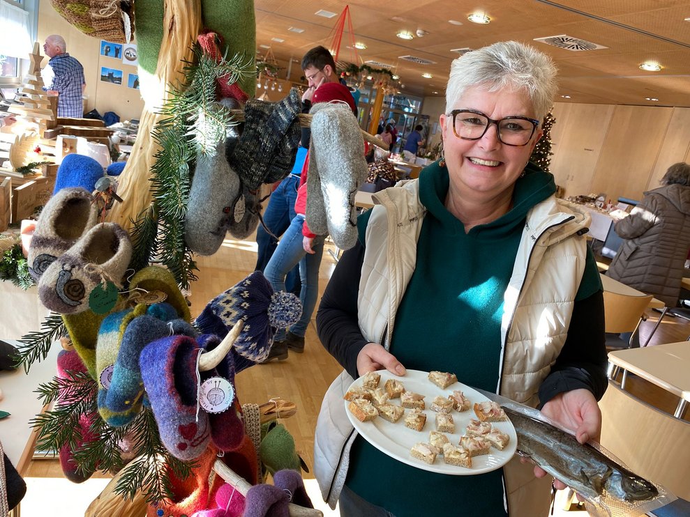 Dame vor ihrem Stand mit Fisch und gestrickte Socken