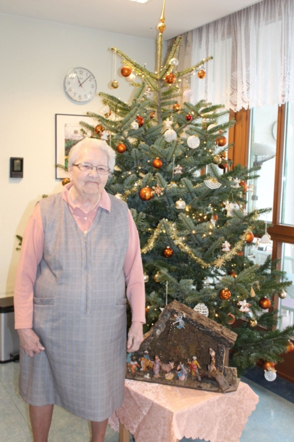 Eine Bewohnerin steht beim Christbaum.