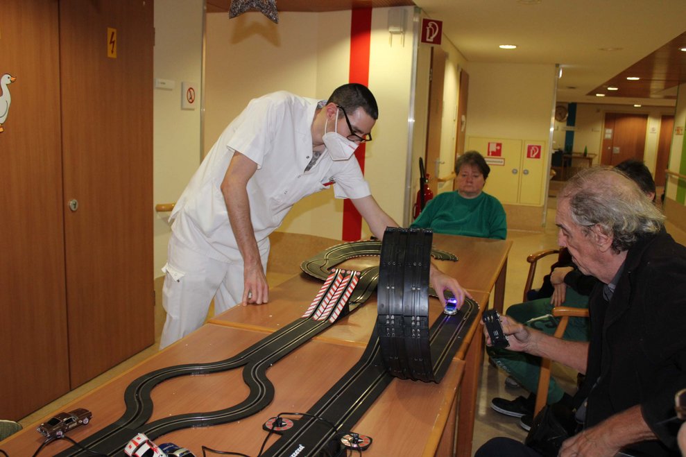 Ein Betreuer und ein Bewohner mit Spielzeugautos.
