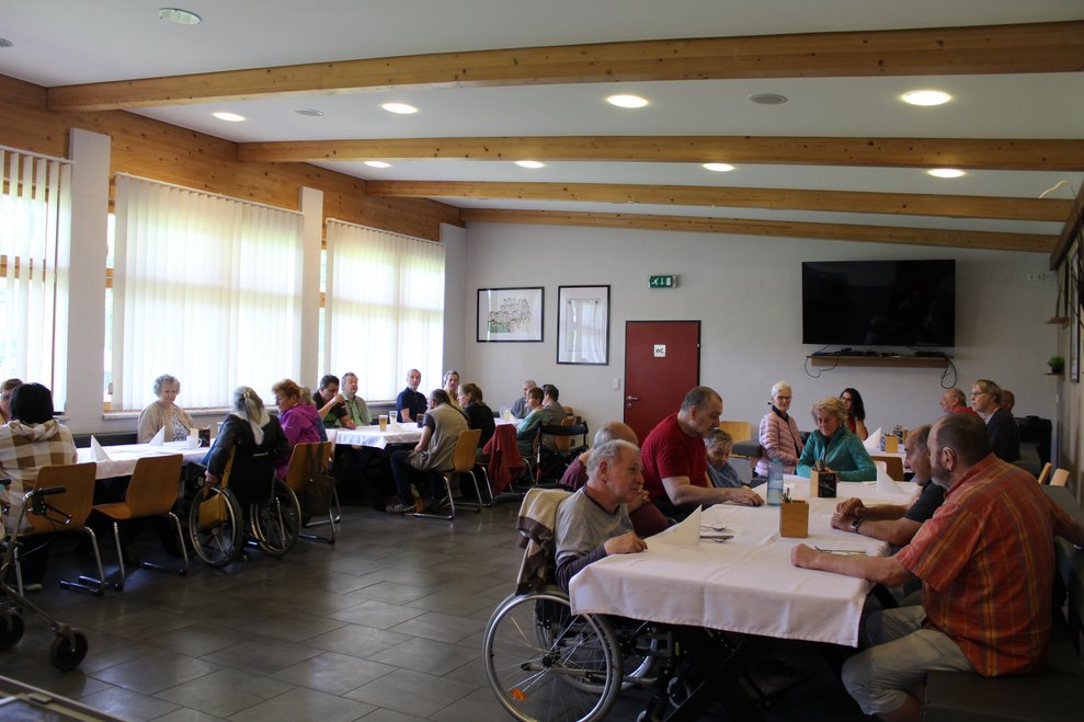 Bewohnerinnen und Bewohner in der Sportkantine beim Essen