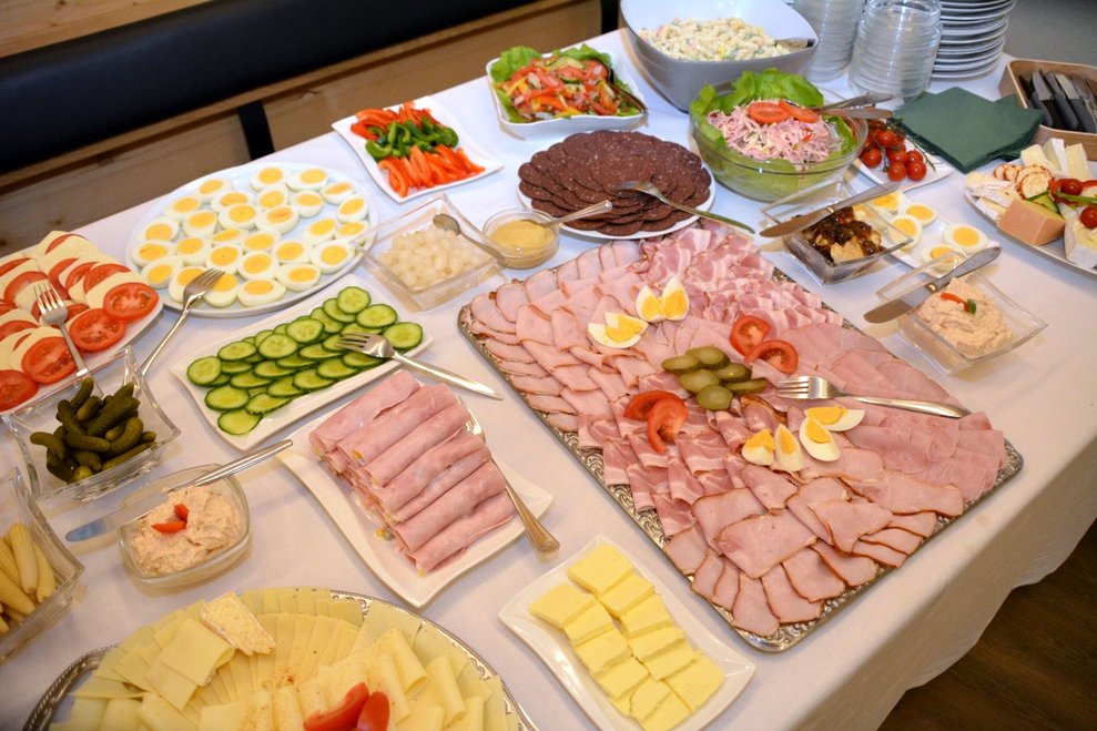 Käse, Wurst, Aufstriche, Gebäck auf Tisch.