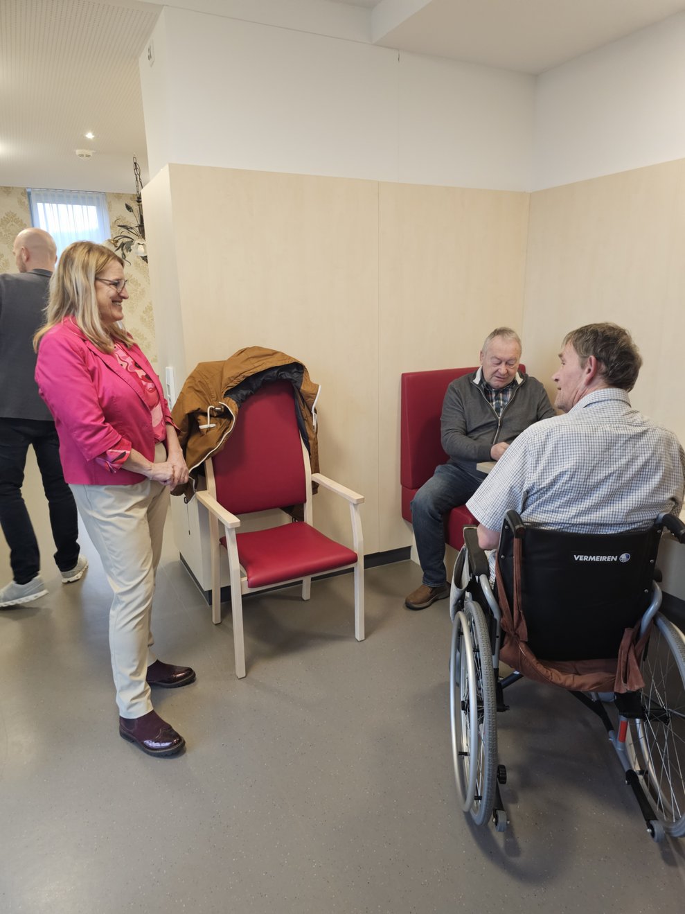 Die Landesrätin plaudert mit zwei Bewohnern.