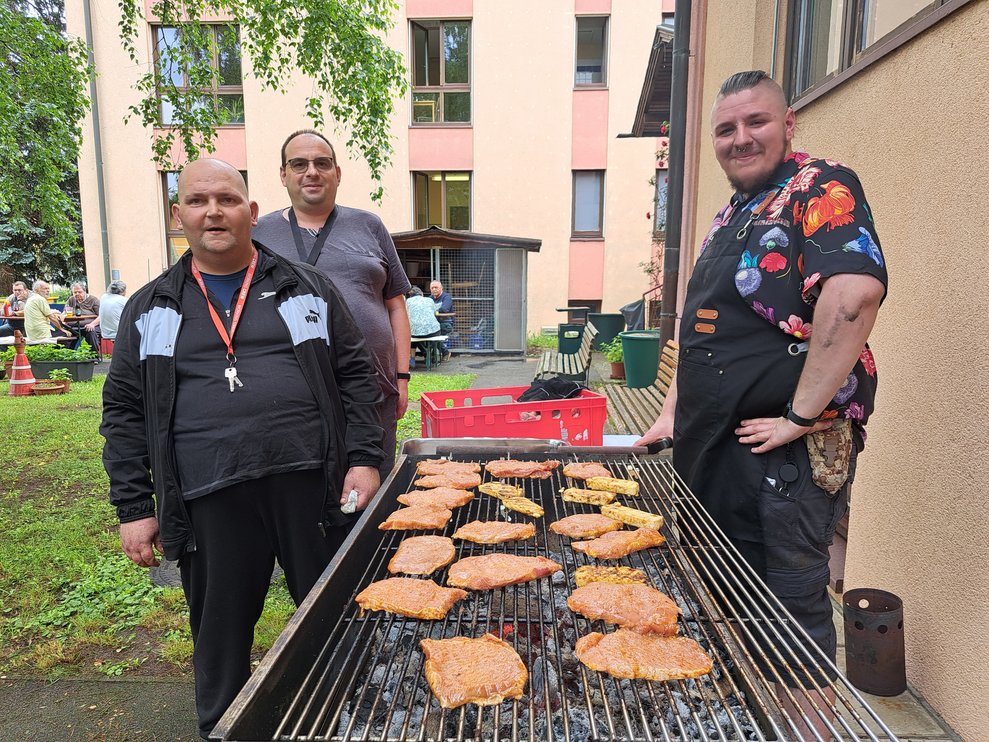 Drei Herren beim Grillen. 