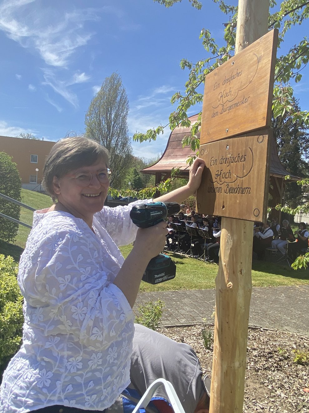 Pflegedirektorin Andrea Wingelhofer befestigt das Schild "Ein Hoch den Bewohnern"