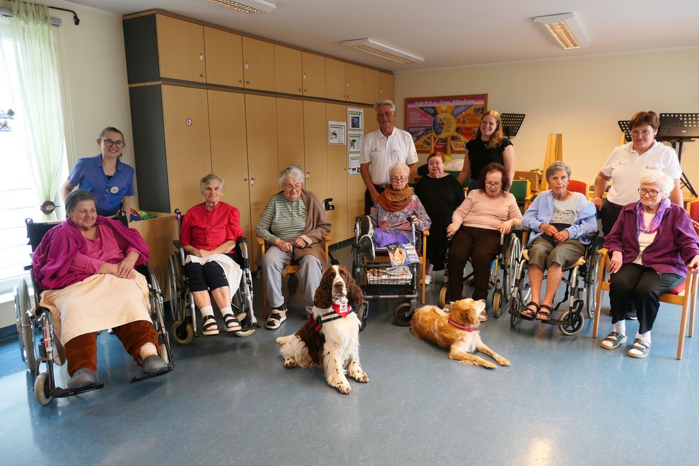 Gruppenfoto mit allen BewohnerInnen, Hunden und Trainer