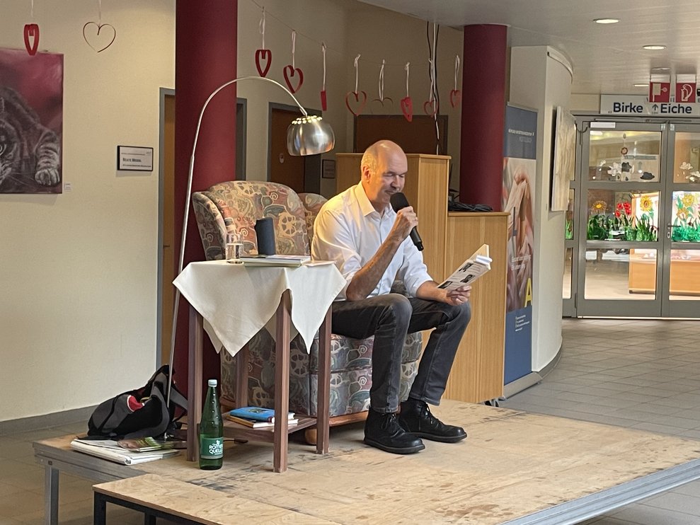 Ein Herr liest auf der Bühne. 