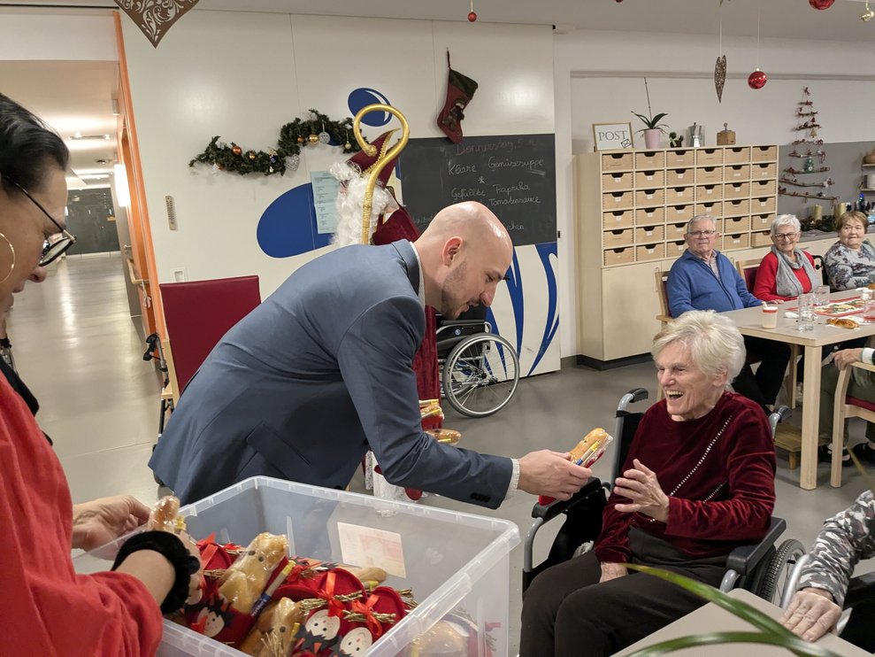 Herr Bürgermeister überreicht einer Dame das Geschenk.