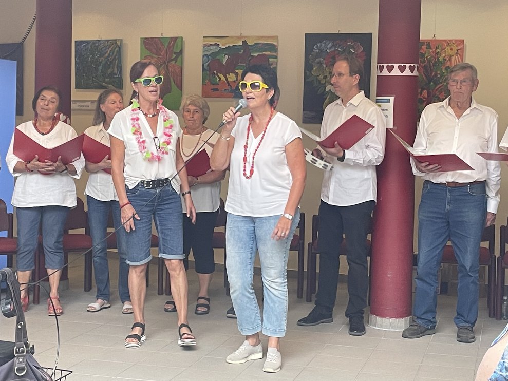 Zwei Damen mit Sonnenbrille singen ein Lied. 