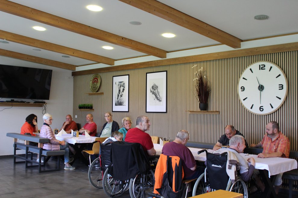 Bewohnerinnen und Bewohner in der Sportkantine beim Essen
