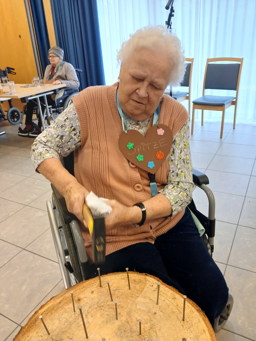 Bewohnerin beim Baumstammnageln
