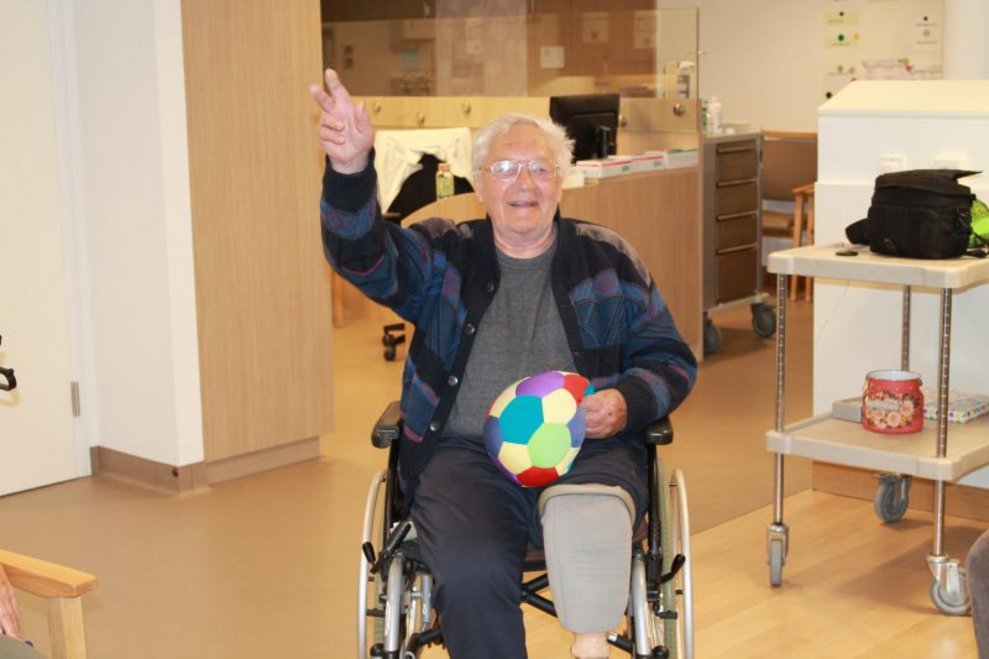 Ein Bewohner hält einen Ball.
