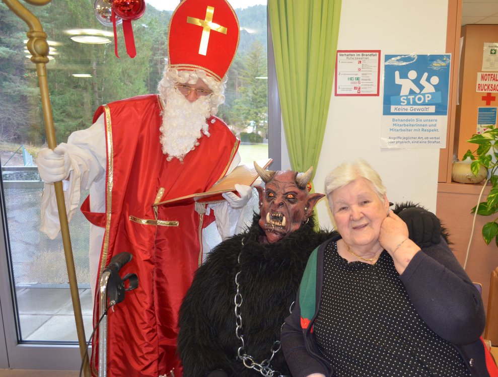 Bewohnerin lächelt mit Nikolo und Krampus